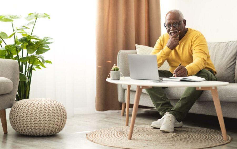 Homem buscando informações online e anotando. Reprodução: Internet