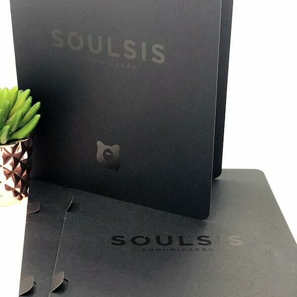 Imagem de uma pasta preta aberta em pé em cima de outra