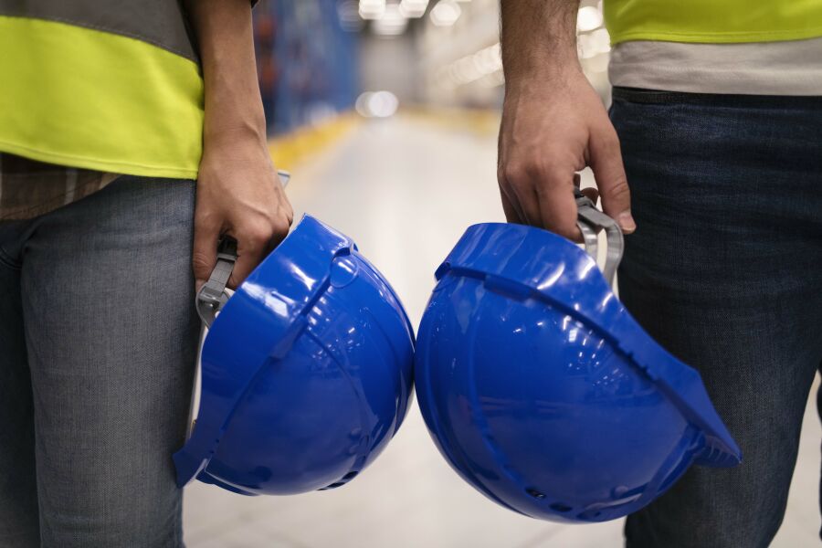 Imagem close-up-two-unrecognizable-industrial-workers-holding-hardhat-protection-helmets%20(1)