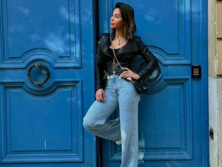 Imagem Maira_Cardi_em_uma_porta_azul