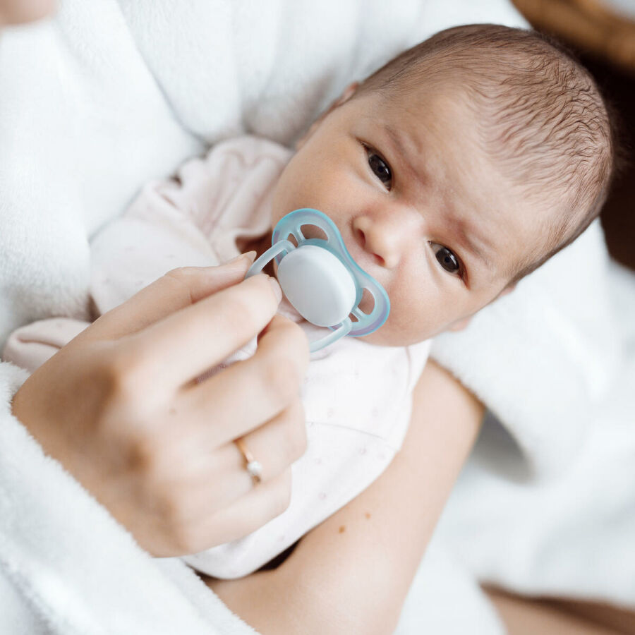 Imagem mae-tentando-dar-a-chupeta-para-o-bebe