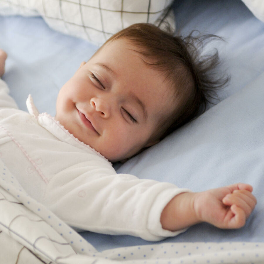 Imagem bebe-de-sorriso-que-encontra-se-em-uma-cama