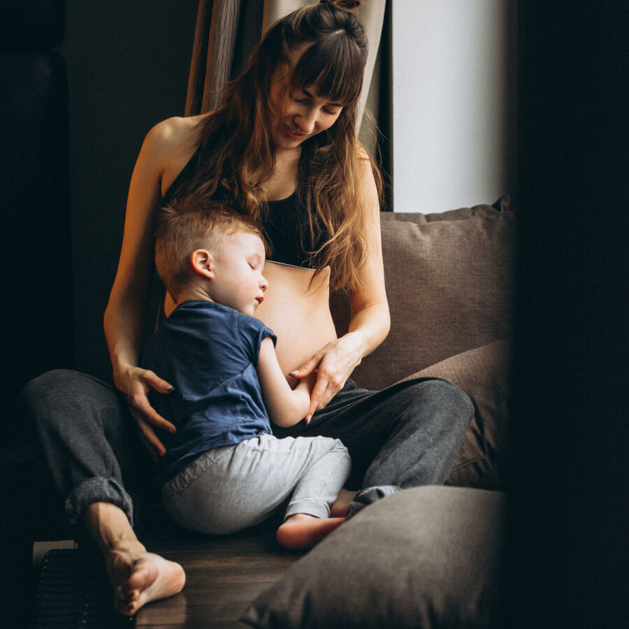 Imagem mae-com-seu-filho-abracando-a-barriga-gravida