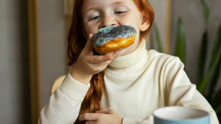 Imagem 16-9-crianca-comendo-donuts-no-cafe