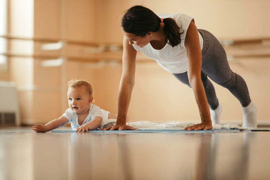 Imagem jovem-mae-exercitando-flexoes-enquanto-esta-em-treinamento-esportivo-com-seu-bebe-copie-o-espaco