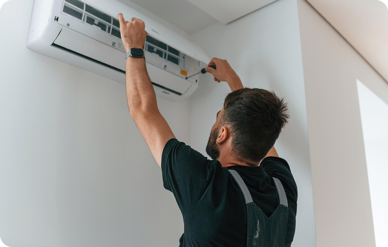 Man som utför underhåll på luftkonditionering